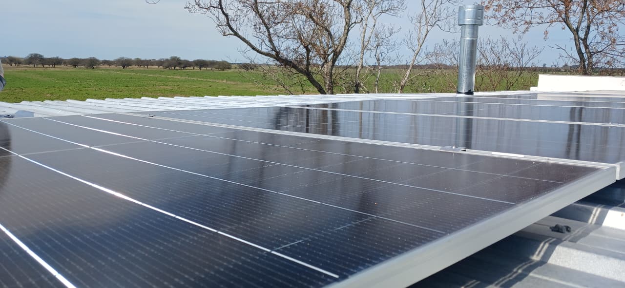 Paneles solares sobre la cubierta de la estancia con el entorno rural de López, Santa Fe