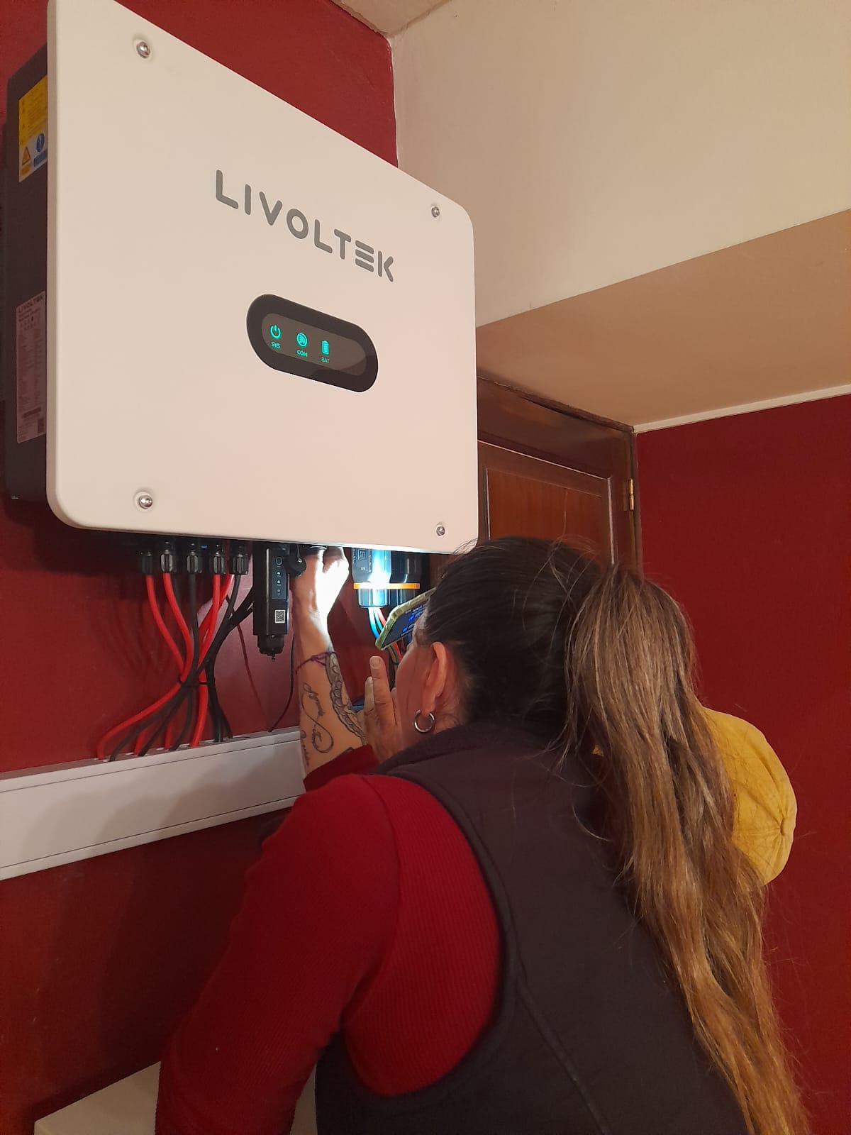 Técnica trabajando en la puesta en marcha del inversor híbrido Livoltek en Viñedo La Alegría